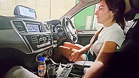 While our car is immobilized in freeway congestion, she grasps my penis in her hand.