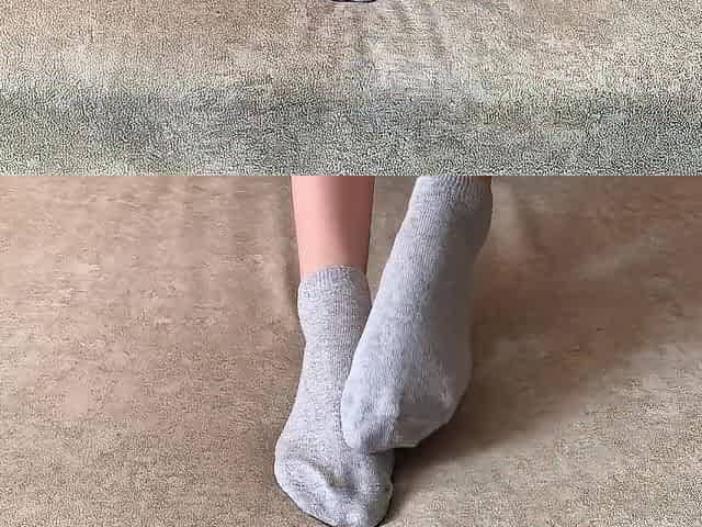 The hotty her legs and takes off her socks with her feet