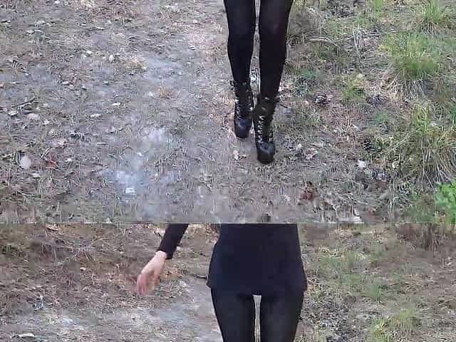 Walking on the wood wearing a ebony suit, hose and high heels ankle boots