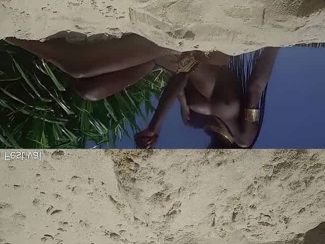 Slim darksome skin angel with a consummate body teasing in the sand outside