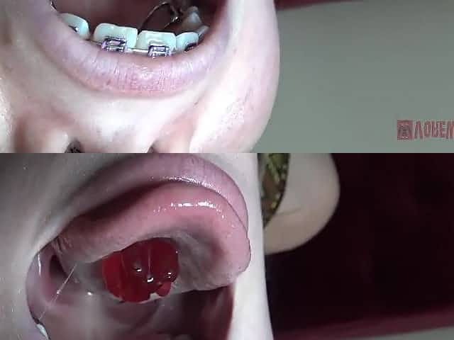 Blue- eyed golden-haired with braces is licking and eating gummy bears in a very hot way