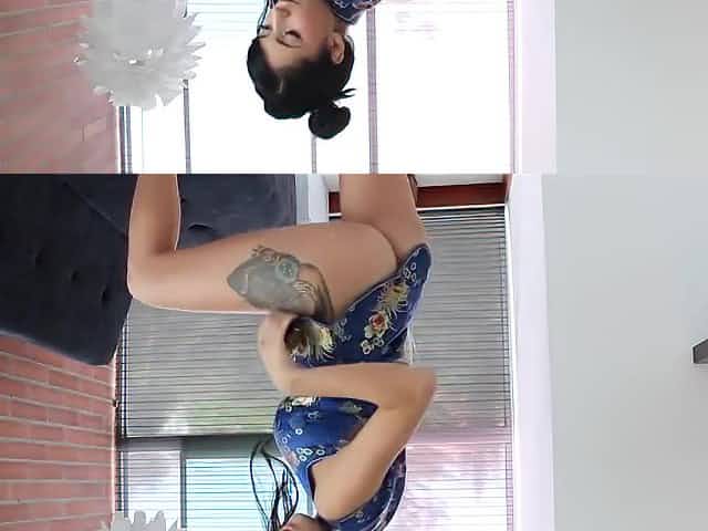Tattooed Asian brunette in a satin dress is spreading her legs wide and masturbating like crazy