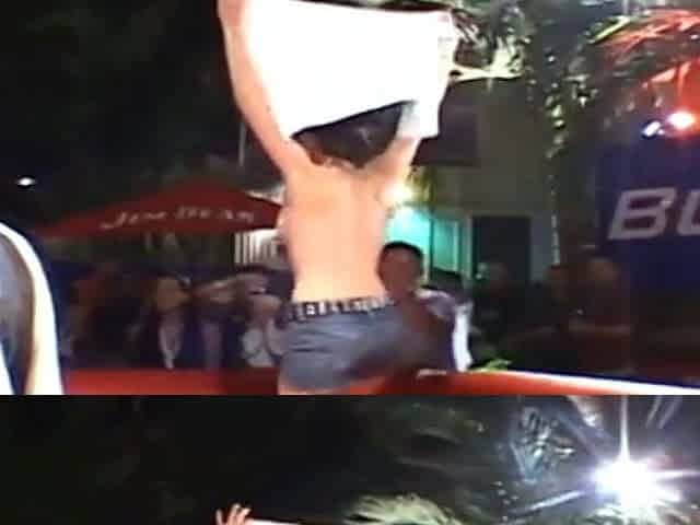 Three topless girls ride a mechanical bull in public