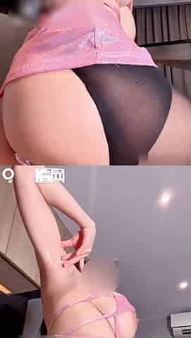 A woman wearing pink lingerie and black stockings is masturbating provocatively. A big penis is penetrating her vagina, it feels