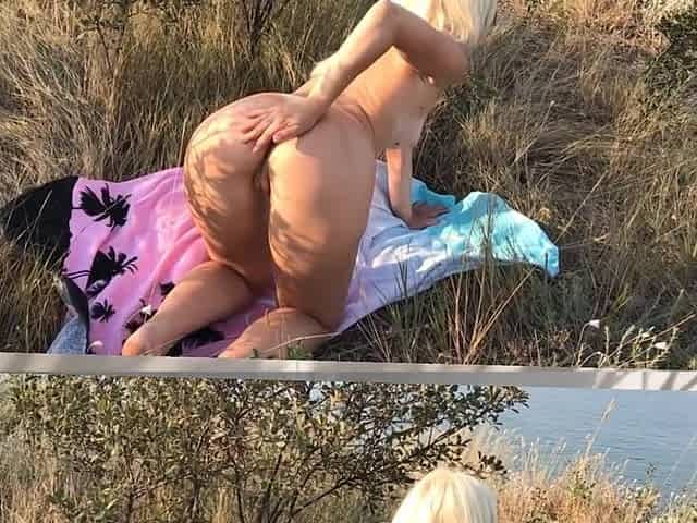 Ardent blond masturbates pink vagina and large booty outdoors