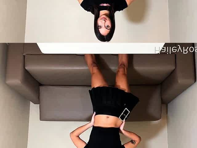 In a kitchen a sexy brunette playing with her big boobs