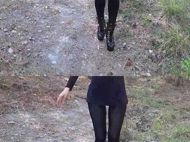 Walking on the wood wearing a ebony suit, hose and high heels ankle boots