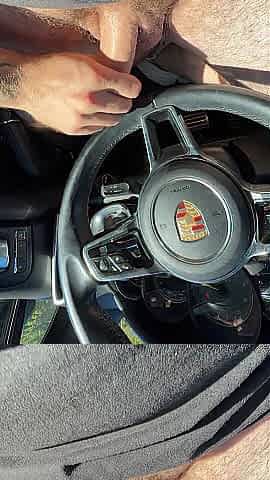 Stroking in public parking lot. Cum on Porsche steering wheel.