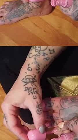 Tattooed blonde lady paints her toenails