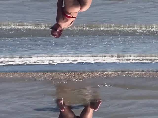 Floozy flashing booty and snatch at beach