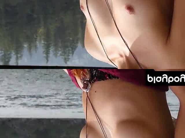 Slender blondie stripping and posing undressed by the river