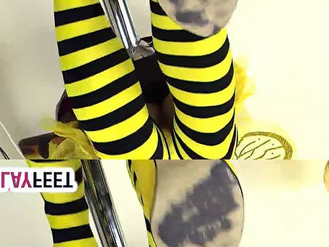 Cosplayer lility is wearing a yellow and ebony bee dress, with yellow high heels and striped socks