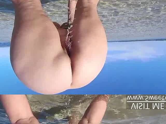 Super large butt peeing on public beach in water