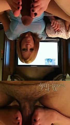 Dashing redhead giving a big cock a foot job in pov