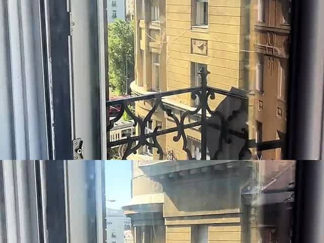 A woman undresses on a balcony in the city center. Public