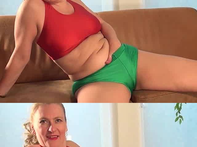 A mature blonde woman named Martine is engaging in playful activity with a cucumber while positioned on a sofa.